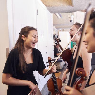 String chamber players laughing while waiting to go on stage